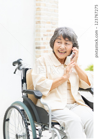 一位坐在輪椅上的老年婦女在用智慧型手機聊天 123767275