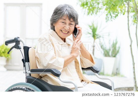 Senior woman in a wheelchair talking on a smartphone 123767276
