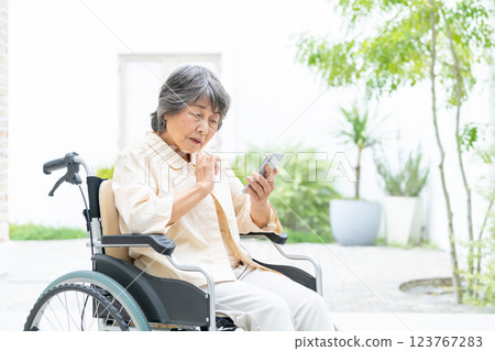 Senior woman in a wheelchair operating a smartphone 123767283