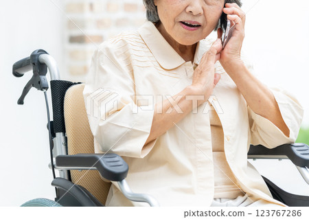 Senior woman in a wheelchair making a phone call Senior woman in a wheelchair making a phone call 123767286