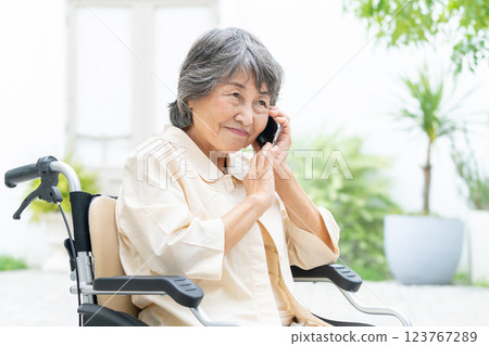 一位坐在輪椅上的老年婦女帶著智慧型手機 123767289