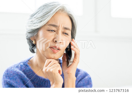 Senior woman talking on smartphone 123767316