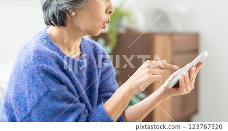 Senior woman operating a smartphone 123767320