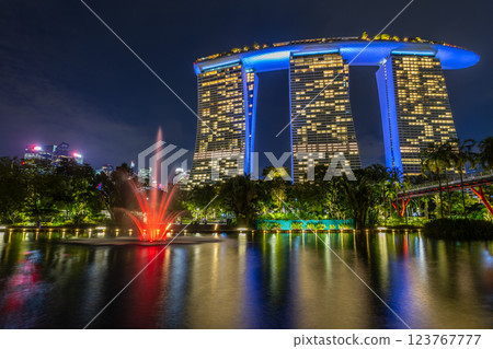 Glowing red fountain and highlighted modern building reflecting in the city park lake, Singapore Glowing red fountain and highlighted modern building reflecting in the city park lake, Singapore 123767777