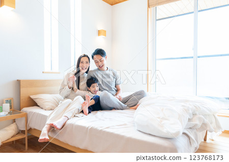 Family sitting on bed Family sitting on bed 123768173
