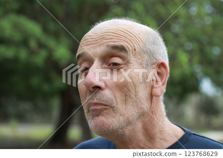 Elderly Man Smiles At An Intrigued Child In The Nature Park Outside Elderly Man Smiles At An Intrigued Child In The Nature Park Outside 123768629