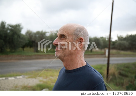 Bald Senior Man Smiles Facial Expression In The Nature Among The Trees 123768630