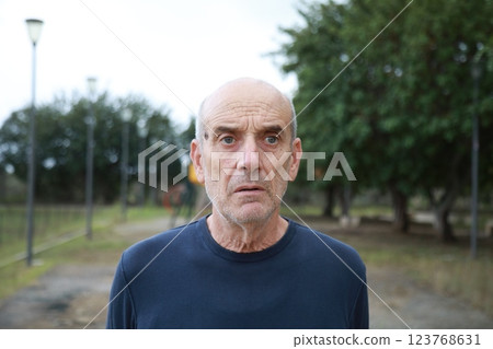 Bald Senior Man In Nature Park Looks In Shock Near Trees Outdoor Bald Senior Man In Nature Park Looks In Shock Near Trees Outdoor 123768631