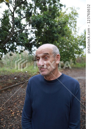 Elderly Man Makes Facial Expression Of We Hope Under A Tree In The Countryside Elderly Man Makes Facial Expression Of We Hope Under A Tree In The Countryside 123768632