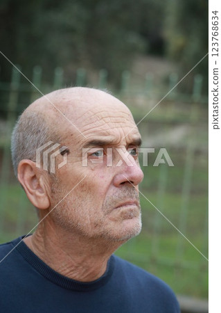 Elderly Man Looks Around Suspiciously In The Park 123768634