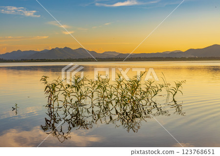 Landscape of mountains and lake at sunset and clouds reflected in the water. Landscape of mountains and lake at sunset and clouds reflected in the water. 123768651