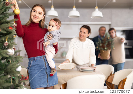 Woman decorating Christmas tree Woman decorating Christmas tree 123770077