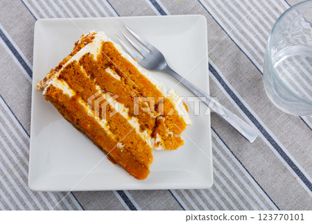 Small triangular piece of carrot cake is on plate Small triangular piece of carrot cake is on plate 123770101
