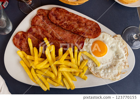 Homemade hearty breakfast - fried eggs with bacon and French fries Homemade hearty breakfast - fried eggs with bacon and French fries 123770155