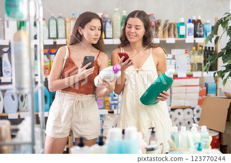 Women friends scanning qr code for detergent Women friends scanning qr code for detergent 123770244