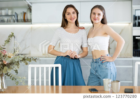 Happy middle-aged mother standing with her young daughter in the kitchen 123770280