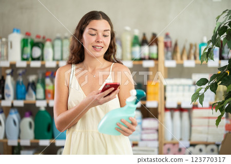 Girl client choose and scanning QR code on package household chemical spray Girl client choose and scanning QR code on package household chemical spray 123770317