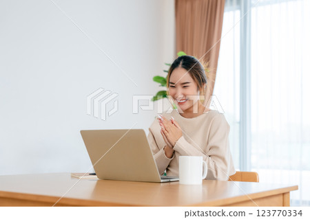 Funny euphoric young asian woman celebrating winning 123770334
