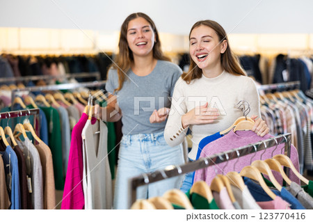 Two happy female friends are shopping in clothing store. Shopping young ladies Two happy female friends are shopping in clothing store. Shopping young ladies 123770416