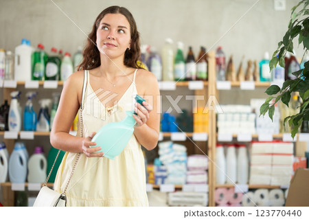 Young woman shopping for glass cleaning spray in home care store Young woman shopping for glass cleaning spray in home care store 123770440