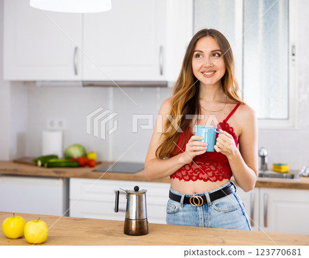 Portrait of laughing woman posing near table with cup of coffee 123770681