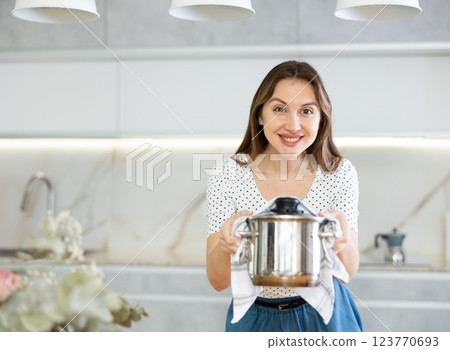 Portrait of a housewife preparing soup in a pot in kitchen 123770693