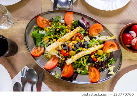 Plate of colorful appetizing salad of fresh greens and vegetables Plate of colorful appetizing salad of fresh greens and vegetables 123770700