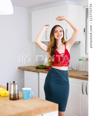 Happy woman dancing in the kitchen at home Happy woman dancing in the kitchen at home 123770734