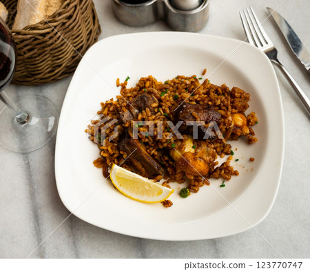 Plate is filled with paella made according to Spanish recipe from rice cereals, seafood, and chicken Plate is filled with paella made according to Spanish recipe from rice cereals, seafood, and chicken 123770747