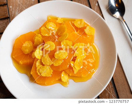 Orange served with honey and corn flakes Orange served with honey and corn flakes 123770757