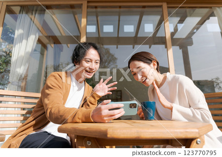 A couple operating a smartphone on the terrace 123770795