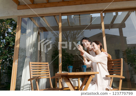 A couple operating a smartphone on the terrace 123770799
