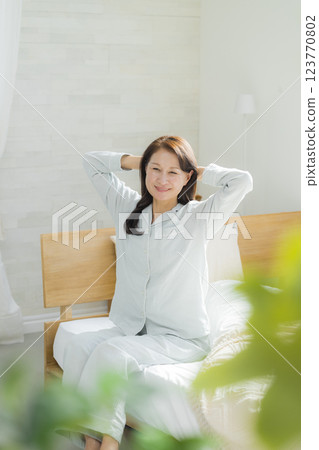 躺在床上伸展身體的老年婦女 躺在床上伸展身體的老年婦女 123770802