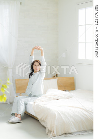 躺在床上伸展身體的老年婦女 123770809