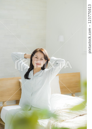 躺在床上伸展身體的老年婦女 123770813