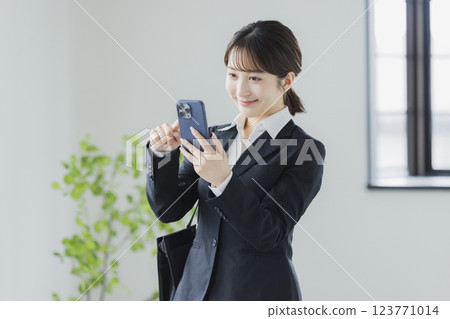 操縱智能手機的衣服的一名婦女 操縱智能手機的衣服的一名婦女 123771014