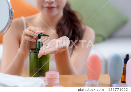 Closeup hands beautiful young woman applying lotion herb on hands looking mirror at home. 123771022