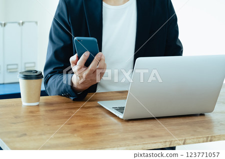 A man who operates a computer and a smartphone 123771057