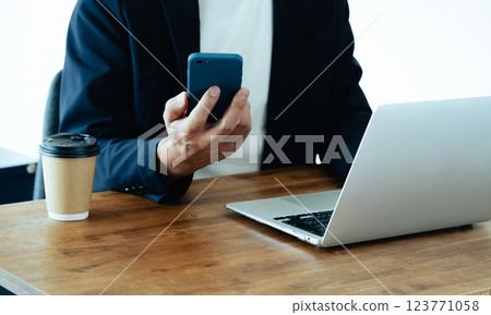 A man who operates a computer and a smartphone 123771058