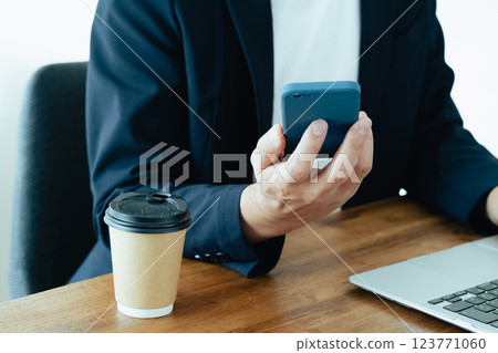 一個操作電腦和智能手機的人 123771060