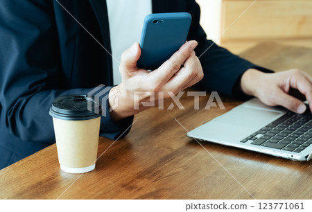 A man who operates a computer and a smartphone 123771061