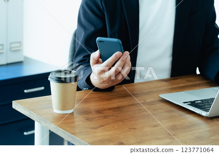 A man who operates a computer and a smartphone 123771064