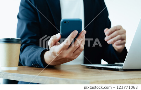 一個操作電腦和智能手機的人 123771068