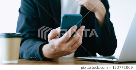 A man who operates a computer and a smartphone A man who operates a computer and a smartphone 123771069