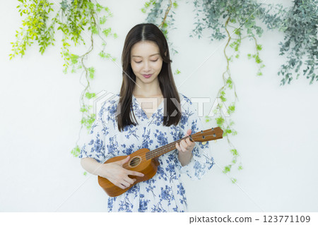 A woman playing an ukulele 123771109