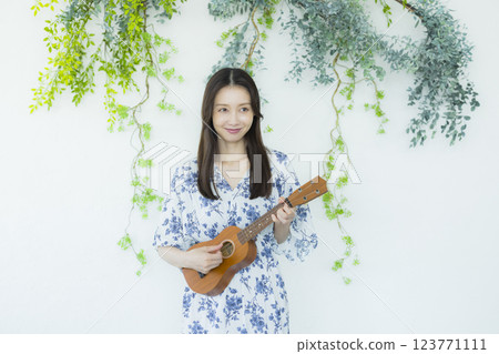 A woman playing an ukulele 123771111