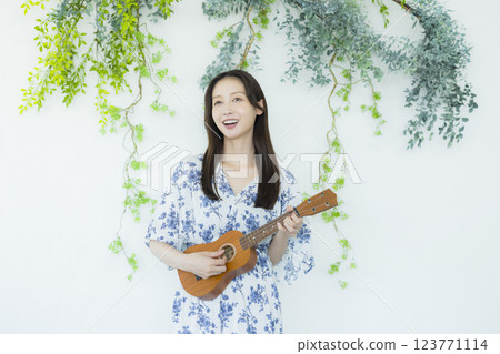 A woman playing an ukulele 123771114