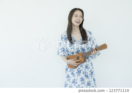A woman playing an ukulele 123771119