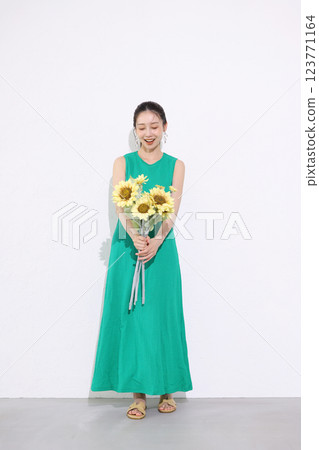 Smiling woman holding a bouquet of sunflowers 123771164