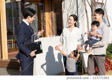 Businessman introducing real estate and a young family 123771991